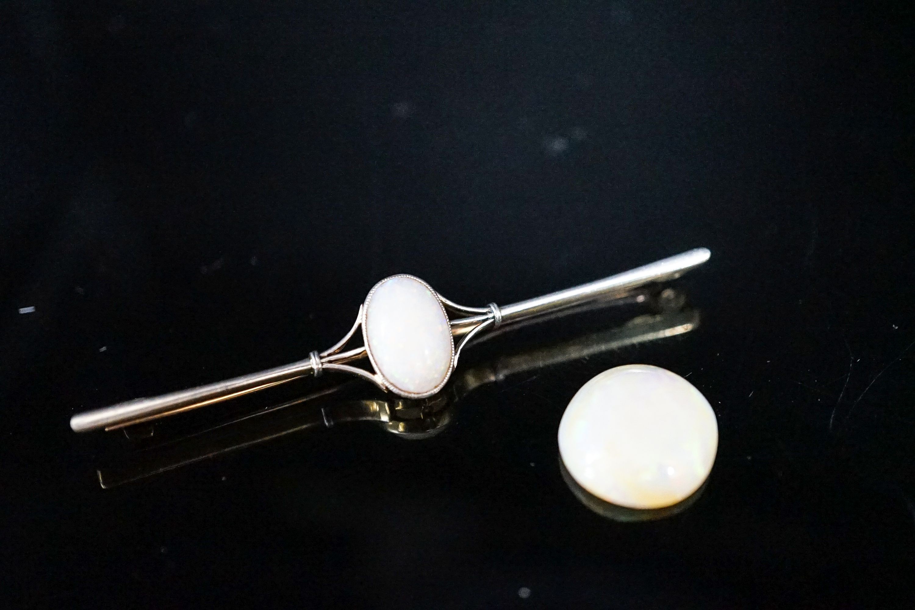 A yellow metal and white opal set bar brooch, 63mm, gross 4.9 grams and a loose white opal.